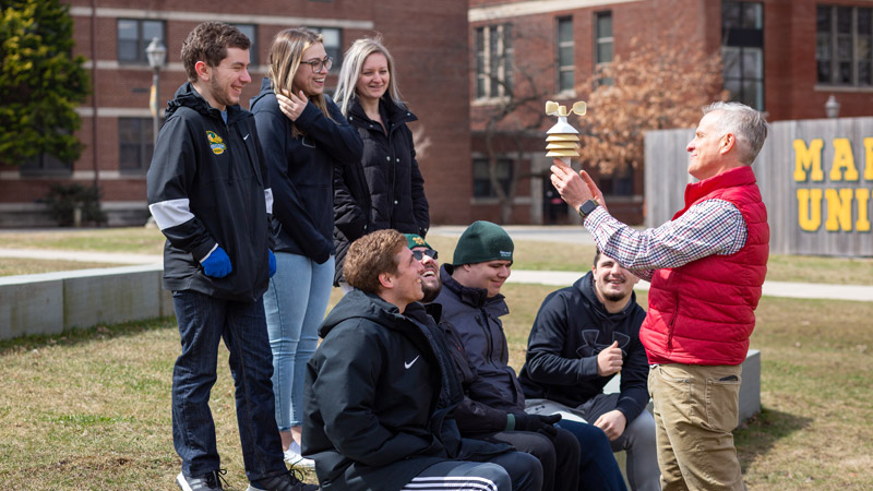 Outdoor photo of professor and students